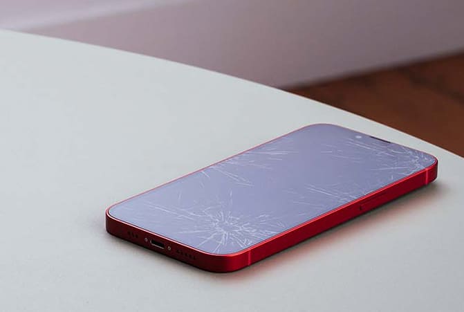 Sobre la mesa hay un teléfono móvil con la pantalla maloliente.
