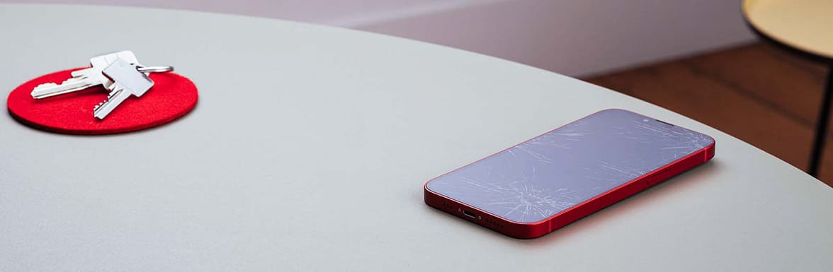 Sobre la mesa hay un teléfono móvil con la pantalla maloliente.