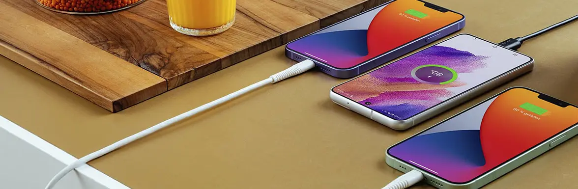 Sobre la mesa hay varios teléfonos que se están cargando.