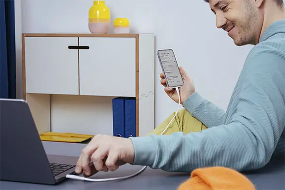 El teléfono móvil se conecta al ordenador por medio de un cable USB.