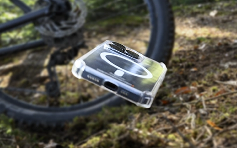 El smartphone en la funda del móvil cae de la moto al suelo del bosque.