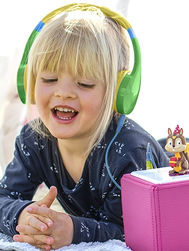 Una niña escucha un programa de radio con los auriculares infantiles Hama «Kids Guard».