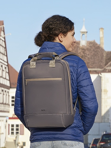 Una joven pasea por la ciudad con la mochila portátil «Ultra Lightweight» de Hama a la espalda