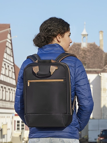 Una joven pasea por la ciudad con la mochila portátil «Ultra Lightweight» de Hama a la espalda